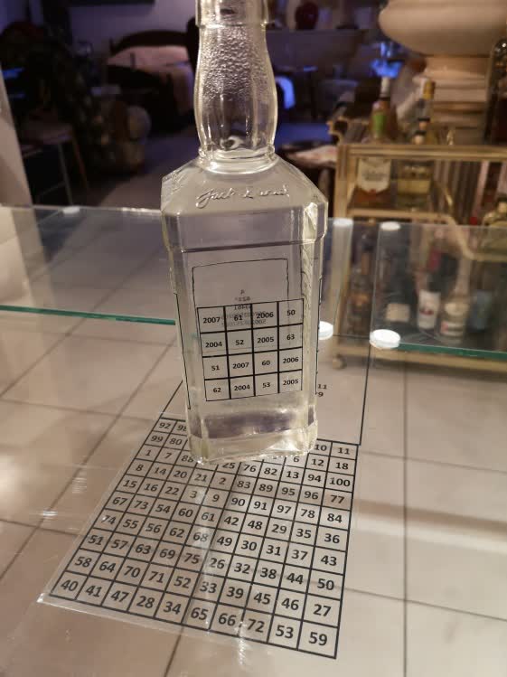 Un carré magique au travail : une bouteille posée sur sa grille, dans l'atelier d'Antoine.