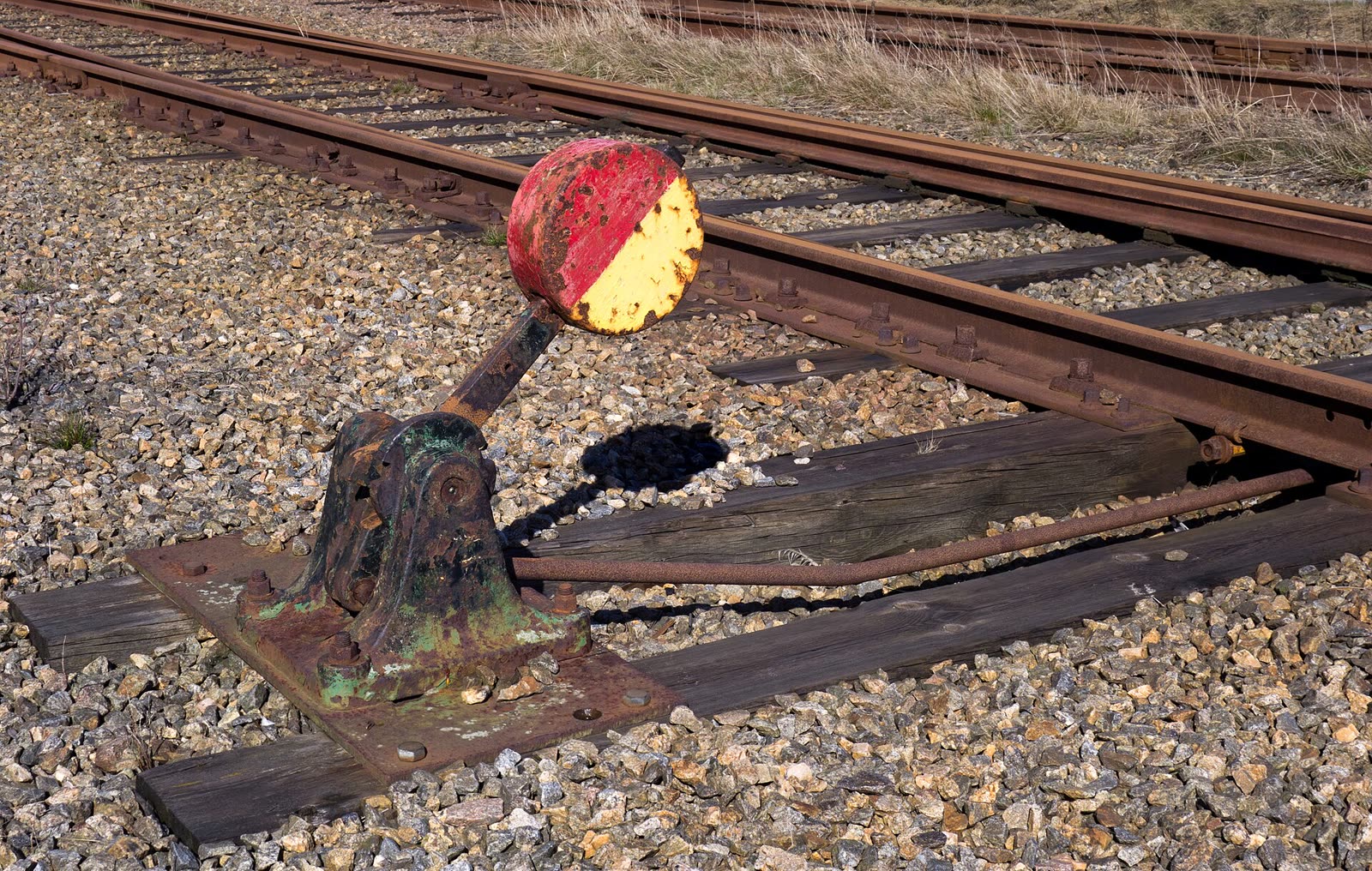 Un levier d'aiguillage au bord d'une voie ferrée