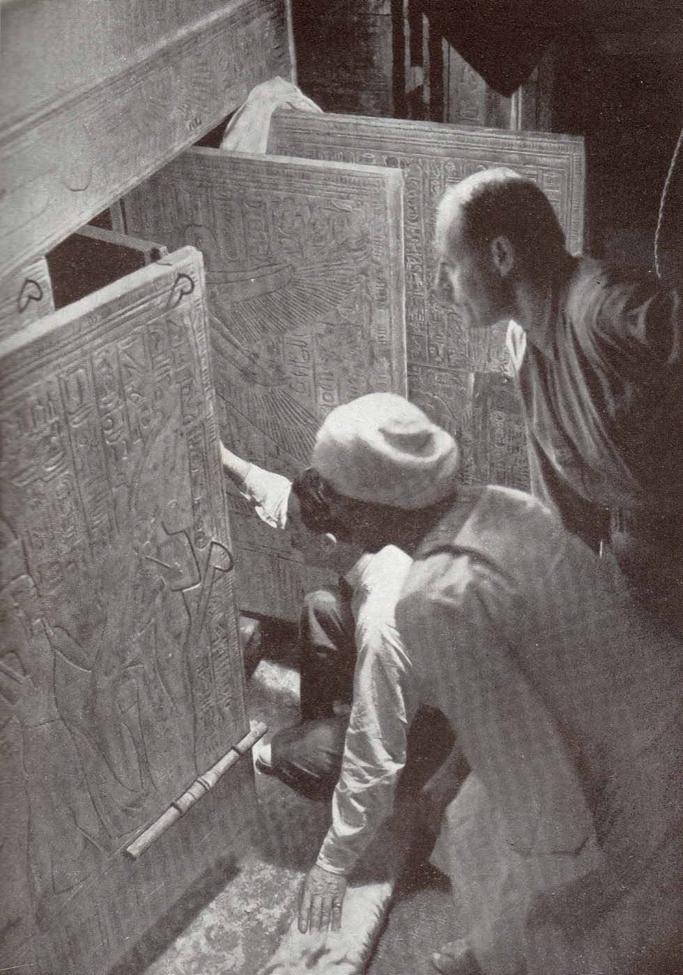 Howard Carter ouvre les portes des chapelles dorées qui protégeaient le sarcophage. Photographie de Harry Burton, domaine public.