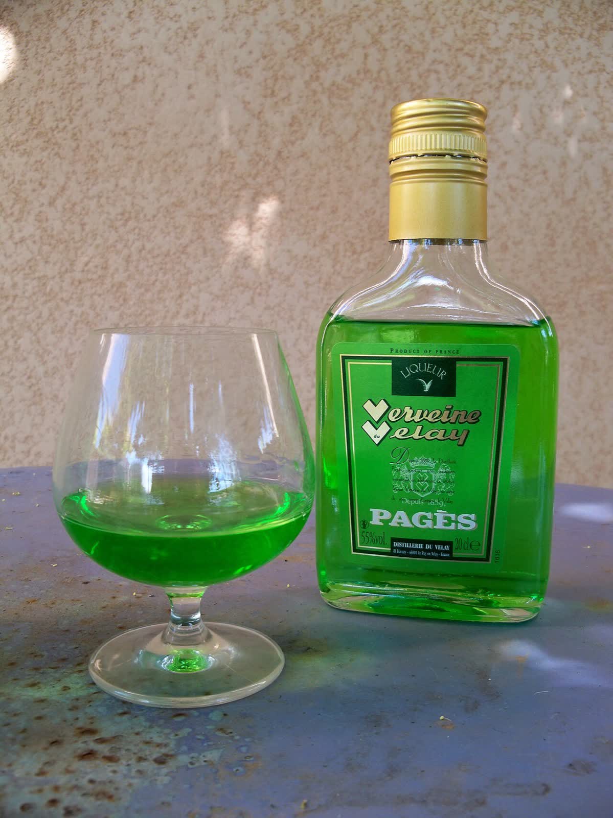 Un flacon de Verveine du Velay et son verre : la « flamme de la Saint-Jean ». Photo Marianne Casamance, CC BY-SA 4.0, Wikimedia Commons.