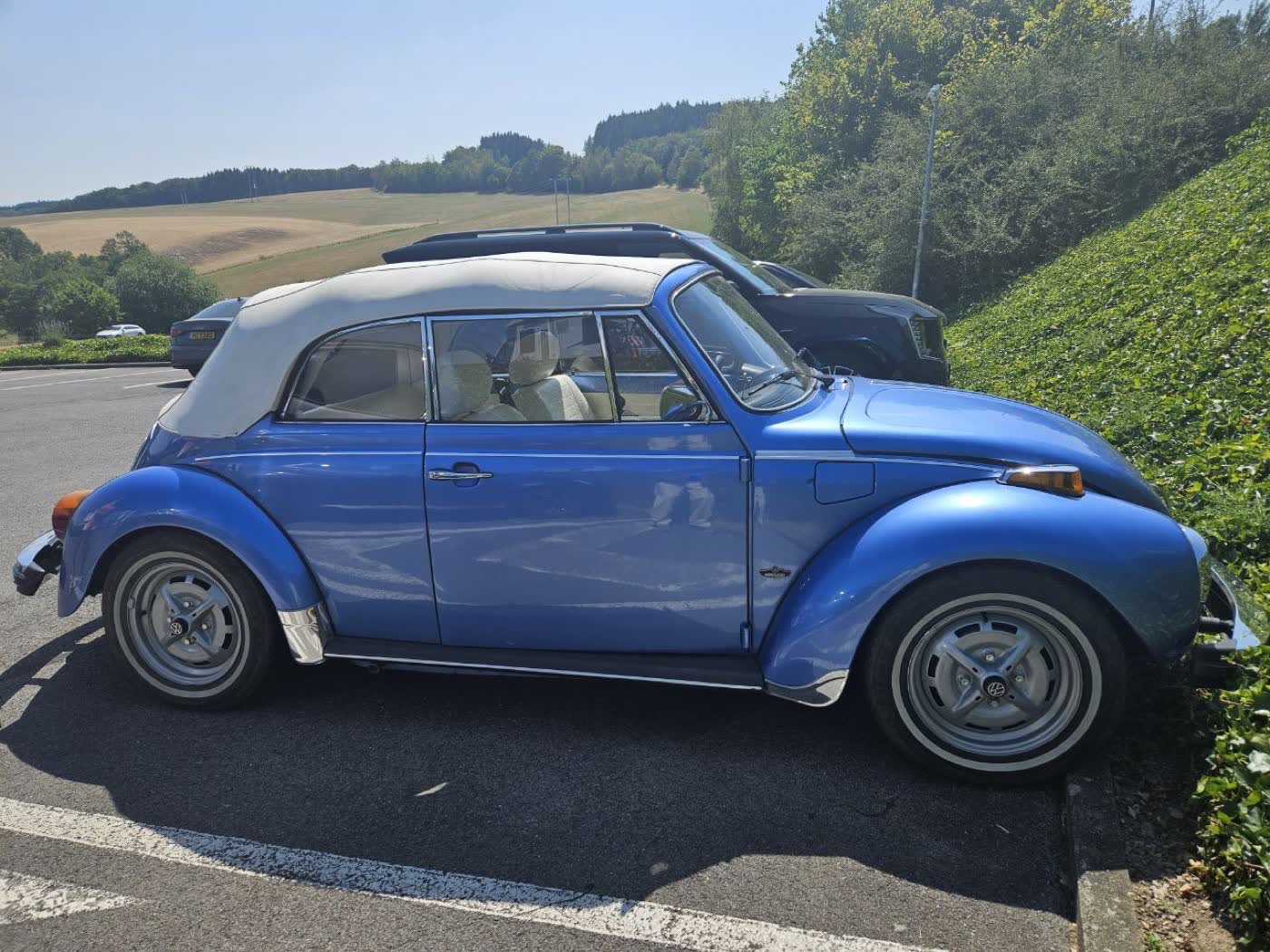 La Coccinelle cabriolet bleu Ancona, capote et sièges blanc neige.